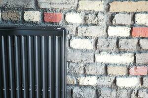 noir radiateur sur ancien mur. appartement chauffage installation système, photo