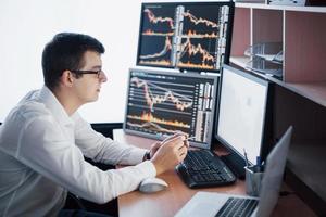 journée de travail chargée. gros plan d'un jeune homme d'affaires regardant un moniteur assis au bureau dans un bureau de création photo