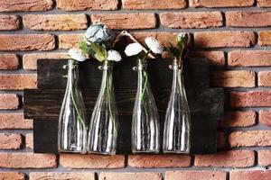 décoration intérieure avec des bouteilles sur mur de briques avec des fleurs. super pour mariage photo