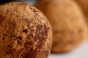 magnifique bonbons truffe sur une blanc assiette sur une noir Contexte photo