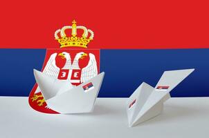 Serbie drapeau représenté sur papier origami avion et bateau. Fait main les arts concept photo