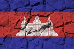 Cambodge drapeau représenté dans peindre couleurs sur vieux pierre mur fermer. texturé bannière sur Roche mur Contexte photo