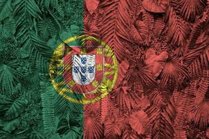 le Portugal drapeau représenté sur beaucoup feuilles de monstera paume des arbres. branché à la mode toile de fond photo