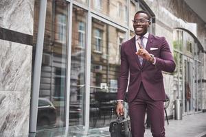 portrait d'un jeune homme d'affaires afro-américain magnifique avec une mallette. réunion d'affaires.