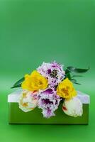bouquet de multicolore tulipes sur cadeau boîte sur vert Contexte. international aux femmes, celle de la mère, la Saint-Valentin jour, Mars 8, anniversaire, vacances. copie espace photo