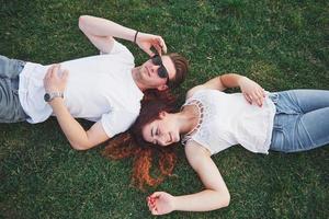 couple gai allongé sur l'herbe. les jeunes à l'extérieur. bonheur et harmonie.