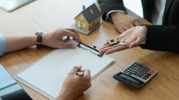 courtier immobilier présente le client à signer le contrat d'achat.