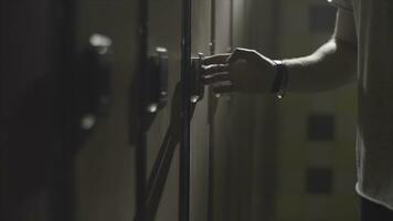 homme main ouverture casier avec électrique clé sur le sien poignet à Gym dans le en changeant chambre. Cadre. proche en haut main ouverture le casier porte dans le en changeant pièce de une salle de sport. photo