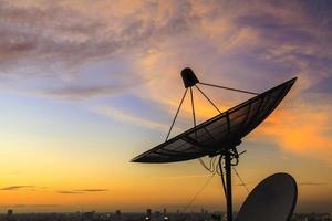 silhouette d'une antenne parabolique au coucher du soleil photo