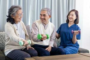 Sénior couple avoir médical un service visite de soignant infirmière à Accueil tandis que haltère exercice muscle force dans Pension retraite centre pour réhabilitation et longévité Publier récupération processus photo