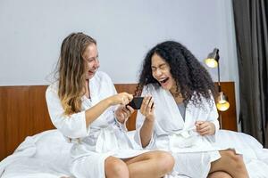 couple de petite amie dans peignoir de bain sont en riant avec le marrant selfie photo pris après sauna sur leur spa vacances pour beauté peau thérapie et traitement