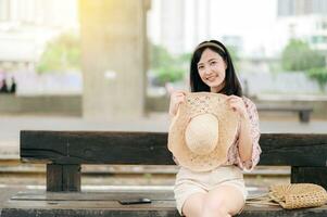 Jeune asiatique femme voyageur avec tissage panier attendre pour train dans train gare. périple voyage mode de vie, monde Voyage explorateur ou Asie été tourisme concept. photo