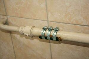 des pansements enveloppé autour chauffage tuyau dans salle de bains à Arrêtez l'eau fuite photo