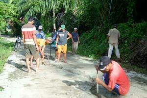 kuaro kalimantan Timour, Indonésie 11 novembre 2023. le village communauté a été vu travail ensemble à réparation le endommagé route photo