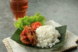 nasi ayam penyet, indonésien épicé poulet avec divers Frais légume photo