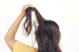 proche en haut femme main tirant sa cheveux, isolé sur blanc Contexte. concept, cheveux tirant désordre ou trichotillomanie. mental santé. psychopathe problèmes. qui démange diriger. photo