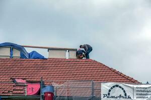 Nitra, la slovaquie - 15.05.2023 bricoleurs réparation cheminées sur le toit de une maison. photo