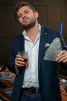 réussi poker joueur avec billets de banque et verre de boisson dans casino photo