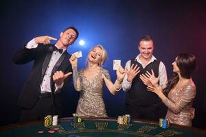 groupe de une élégant riches copains sont en jouant poker à casino. photo