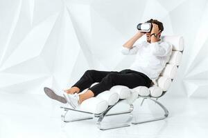 excité Jeune homme est avoir expérience en utilisant casque de RV des lunettes de virtuel réalité gesticuler avec le sien mains photo