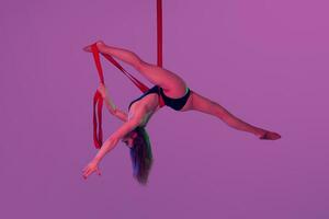 magnifique fille dans une noir maillot de bain est performant un acrobatique éléments dans studio. photo