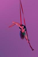 magnifique fille dans une noir maillot de bain est performant un acrobatique éléments dans studio. photo