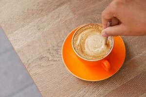 main de personne en remuant le café avec une cuillère. photo