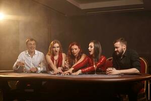 groupe de une Jeune riches copains sont en jouant poker à une casino. photo