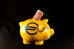 une Jaune porcin banque avec une euro signe sur il photo