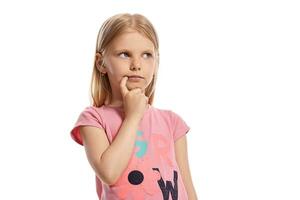 fermer portrait de une agréable blond peu enfant dans une rose T-shirt posant isolé sur blanc Contexte. photo