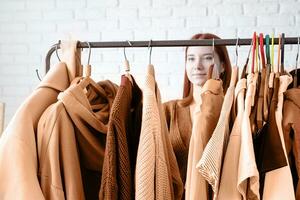 Couleur de le année 2024, pêche duvet. Jeune femme portant beige manteau, permanent près vêtements grille photo