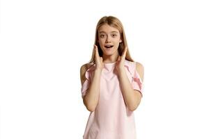 studio portrait de une magnifique fille blond adolescent dans une rose T-shirt posant isolé sur blanc Contexte. photo