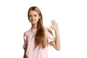 studio portrait de une magnifique fille blond adolescent dans une rose T-shirt posant isolé sur blanc Contexte. photo