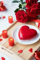 cœur en forme de vitré Valentin gâteau et bougies dans en bois plateau photo
