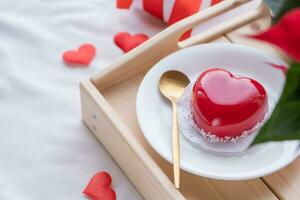 cœur en forme de vitré Valentin gâteau dans lit sur en bois plateau photo