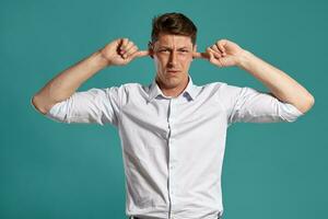 portrait de une Jeune brunet homme posant dans une studio contre une bleu Contexte. photo