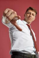 portrait de une Jeune brunet homme posant dans une studio contre une rouge Contexte. photo