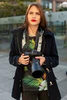 attrayant touristique femme photographe avec caméra, Extérieur dans ville rue. photo