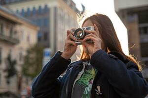 portrait d'une jolie jeune touriste prenant des photos avec un appareil photo rétro vintage