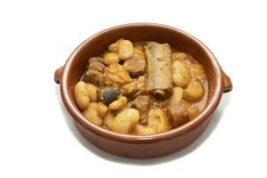une terre cuite assiette avec asturien Fabada, une typique Espagnol haricot ragoût, sur une blanc Contexte. Espagnol nourriture concept. photo
