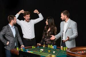 groupe de Jeune gens derrière roulette table photo