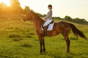 Jeune femme équitation une cheval sur le vert champ photo