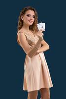 Jeune magnifique femme en portant le gagnant combinaison de poker cartes sur foncé bleu Contexte. deux as photo