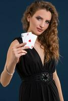 magnifique brunette en portant deux as comme une signe pour poker jeu, jeux d'argent et casino photo