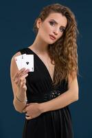 magnifique brunette en portant deux as comme une signe pour poker jeu, jeux d'argent et casino photo