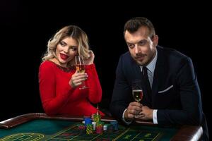 magnifique et bien habillé couple en jouant roulette dans le casino photo