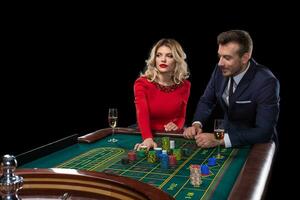 magnifique et bien habillé couple en jouant roulette dans le casino photo
