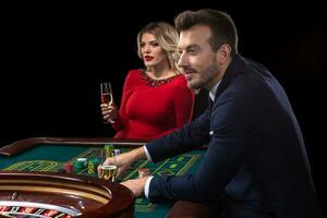 une magnifique Jeune femme et une homme sont séance à une roulette tableau. casino. photo