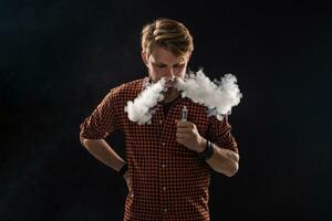 une Jeune homme avec une barbe et une élégant coiffure dans une chemise, fumeur une cigarette, une vipère, une chambre, une studio, fumée, jouissance photo