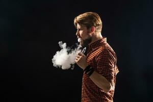 une Jeune homme avec une barbe et une élégant coiffure dans une chemise, fumeur une cigarette, une vipère, une chambre, une studio, fumée, jouissance photo